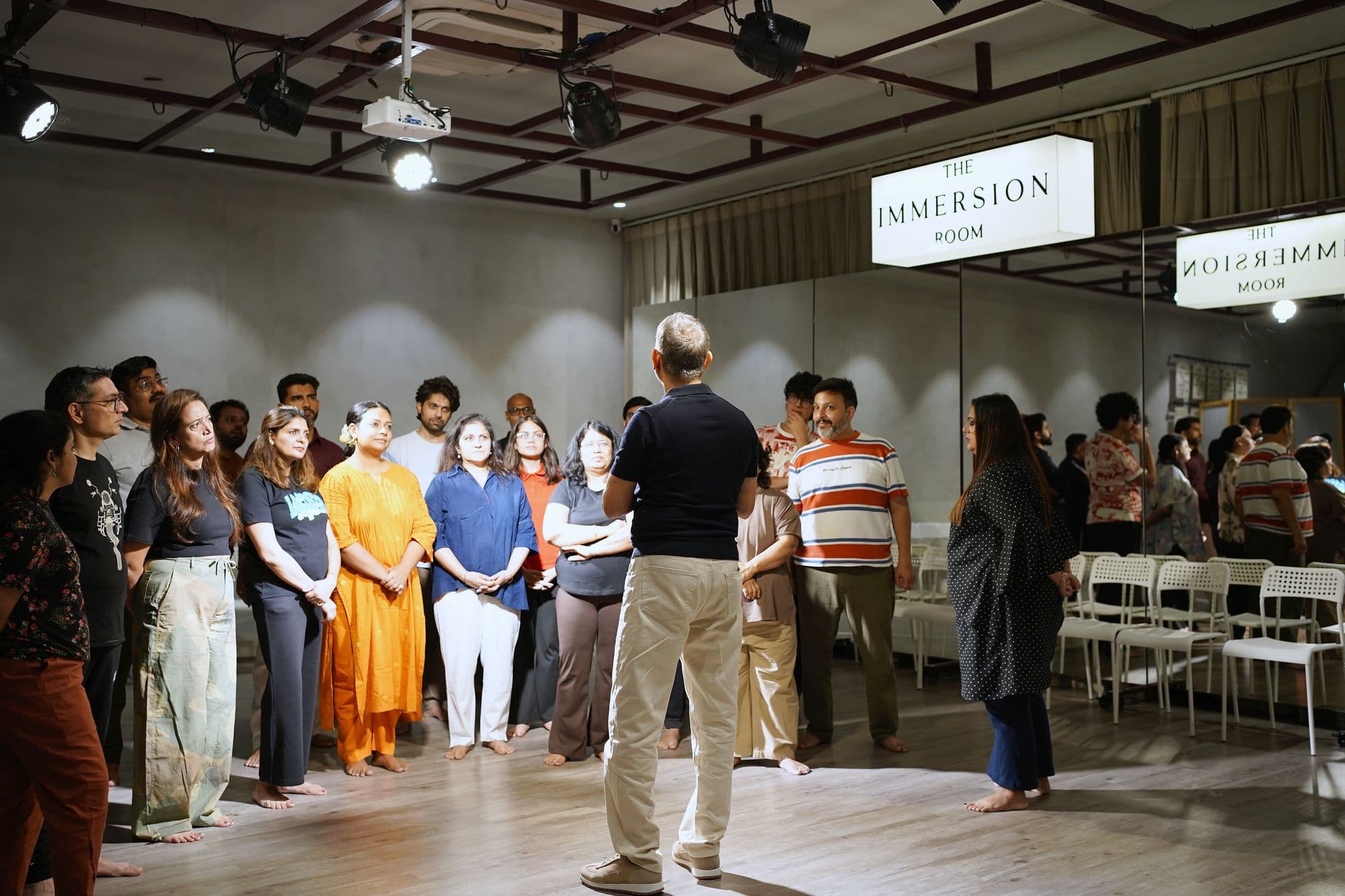 Neeraj Kabi standing in the middle of a circle of participants at The Immersion Room, Gurugram