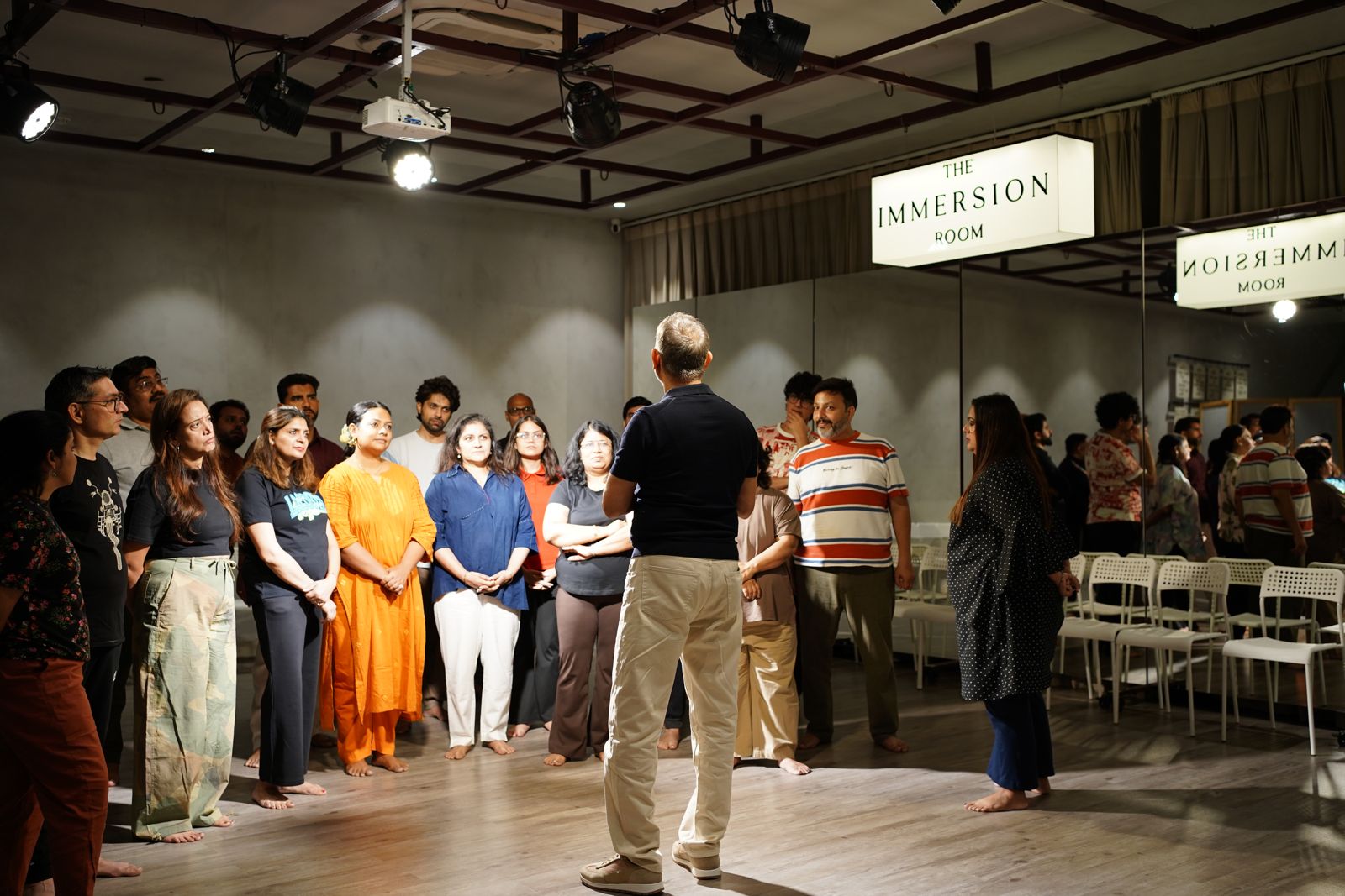 A workshop group standing in a circle around the facilitator