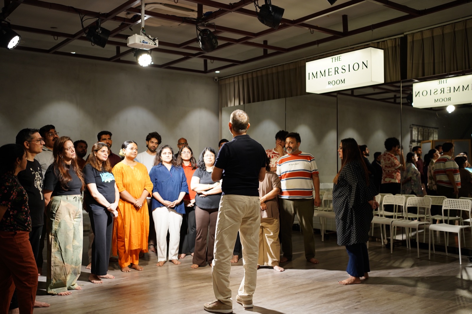 The whole Actor's Power room standing in a circle round Neeraj Kabi