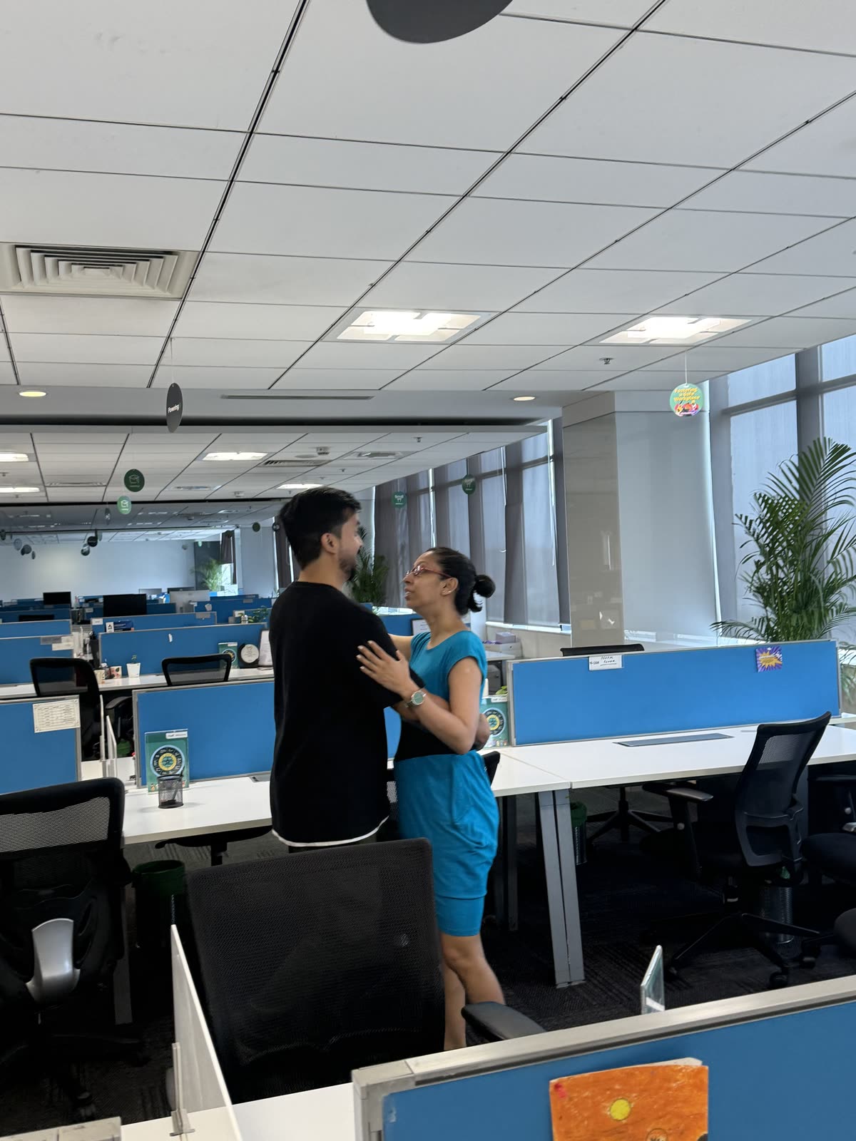 Two Tamasha actors playing a devised scene between desks during the PayU “It's Not My Job!” floor activation