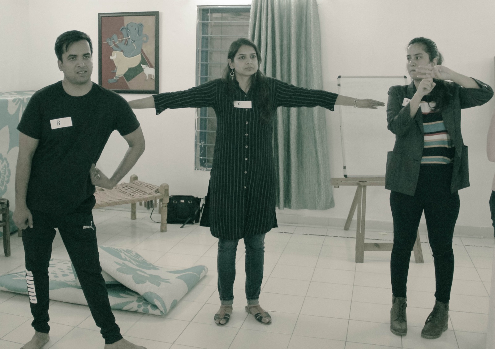 Participants working on stage presence with outstretched arms in a leadership workshop